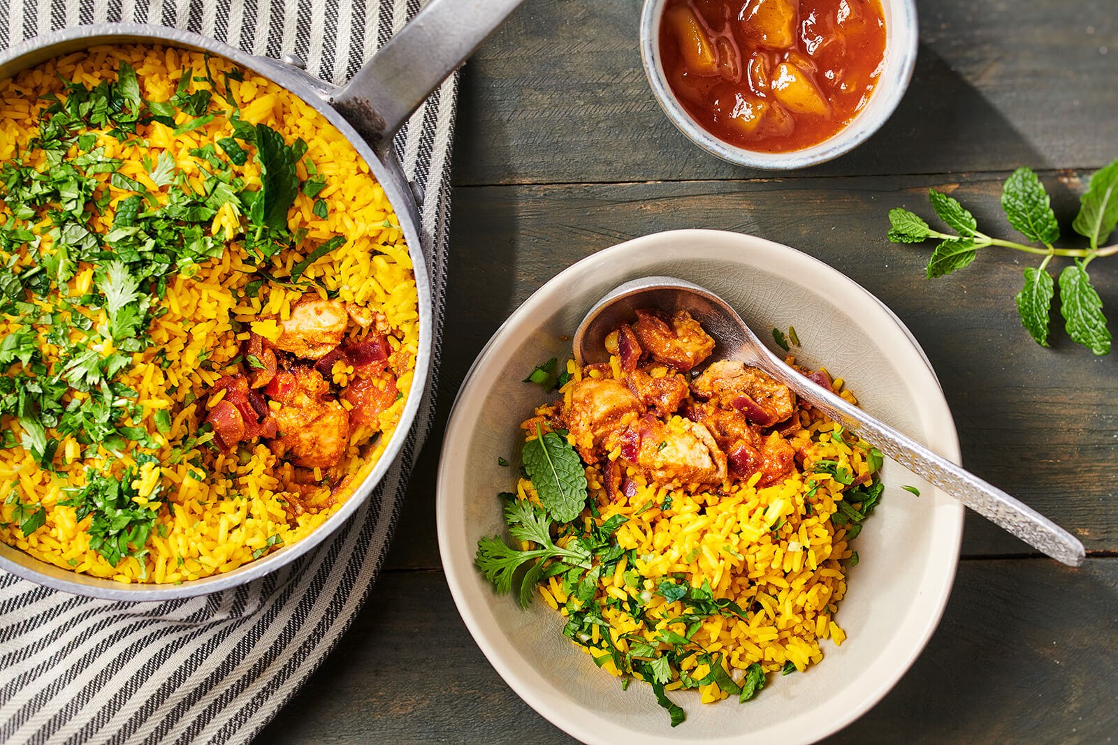 Kruidige kip-biryani met gele rijst en koriander